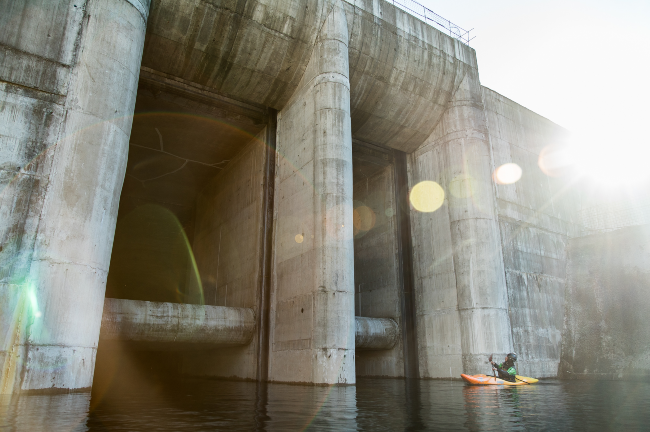 The kayakers in front of a dam. Photo: Carlos Lastra